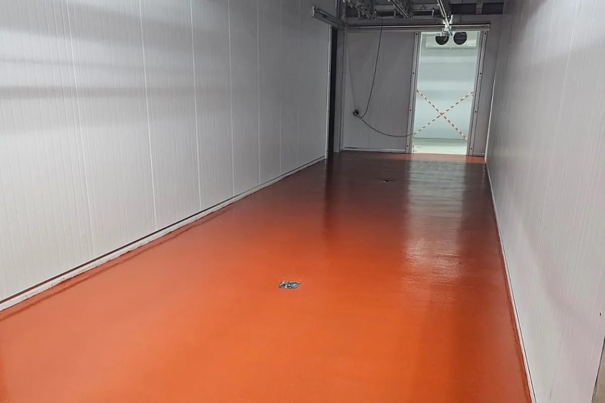 Orange industrial resin floor installed in a processing area by Superior Resin Solutions