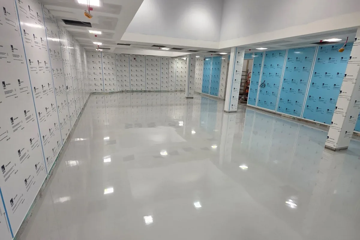 Glossy light grey resin floor installed in a large commercial interior by Superior Resin Solutions