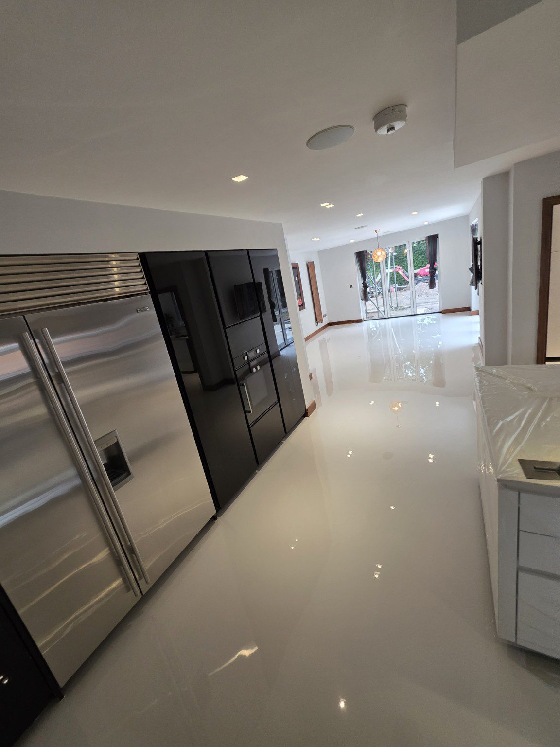 Light coloured Arturo Comfort Floor domestic resin flooring beside a modern kitchen
