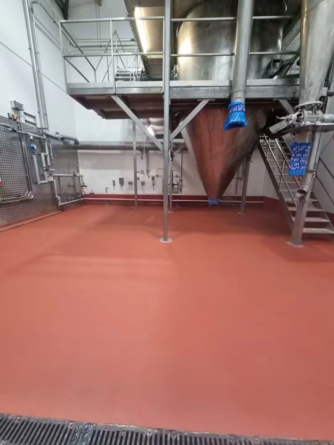 Completed red Resdev Pumadur HF polyurethane floor screed around food processing equipment in Ebbw Vale