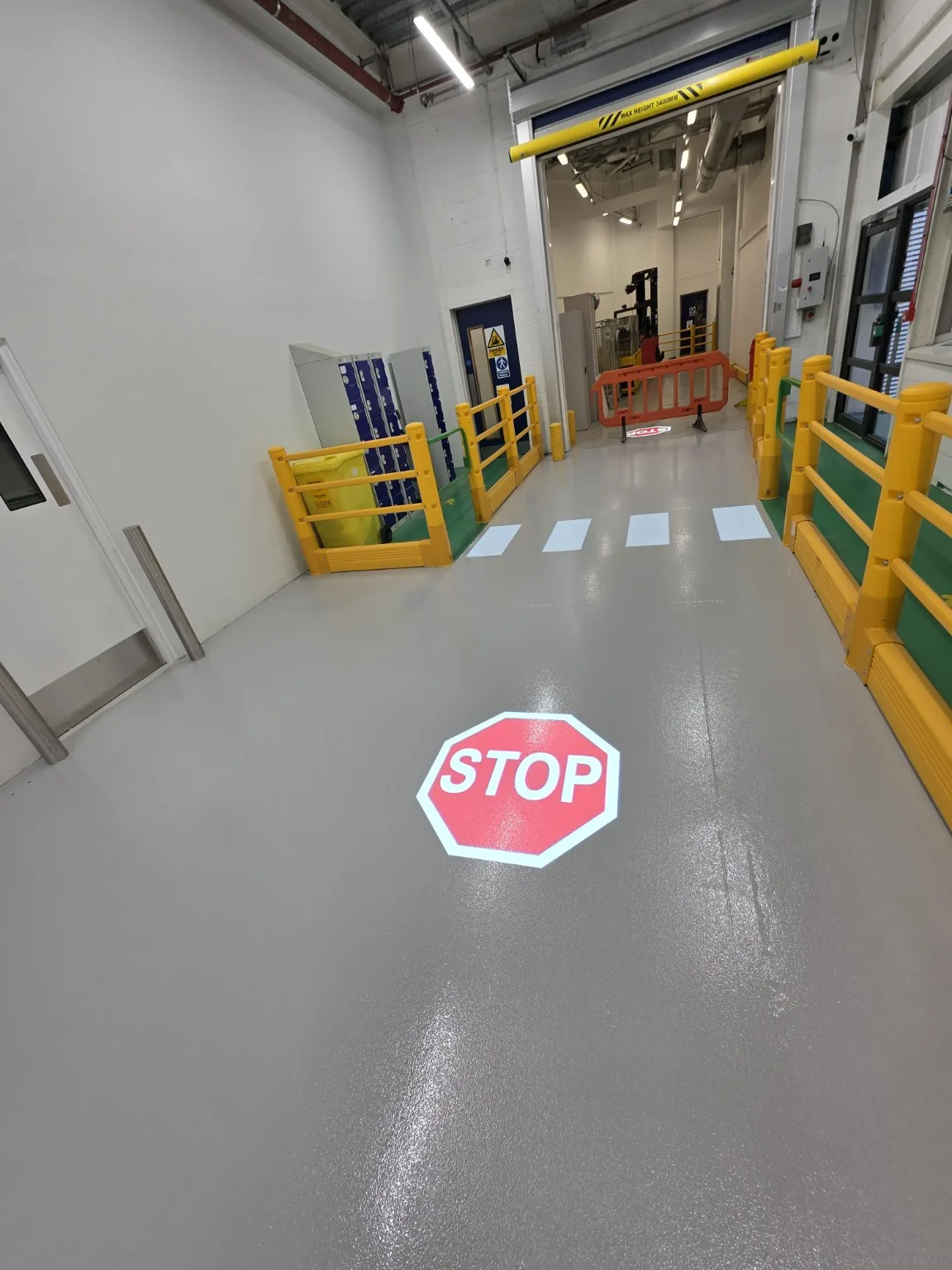 Industrial factory floor with STOP marking and pedestrian crossing line markings