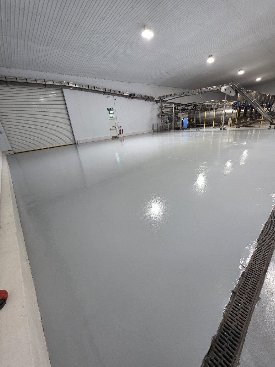 Light grey industrial resin flooring beside manufacturing equipment