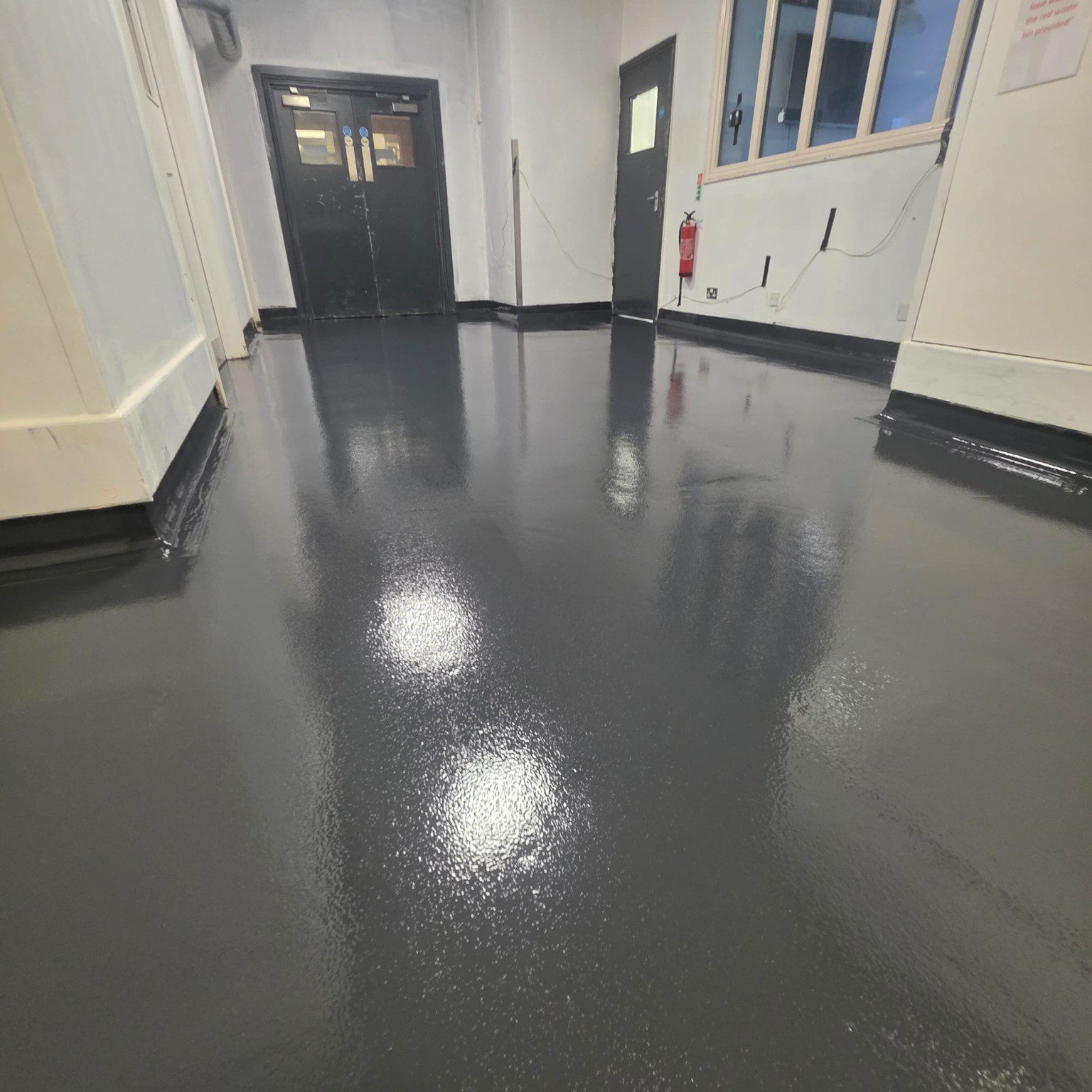 Dark grey resin flooring installed in a Novotel back-of-house corridor