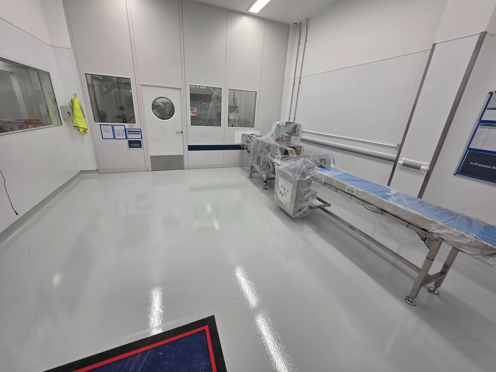 High-build epoxy flooring around pharmaceutical production conveyor equipment