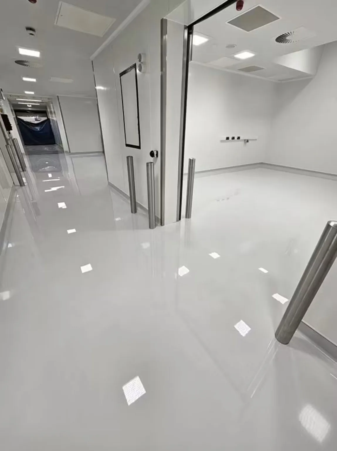 Self-levelling resin flooring extending into a pharmaceutical manufacturing production room