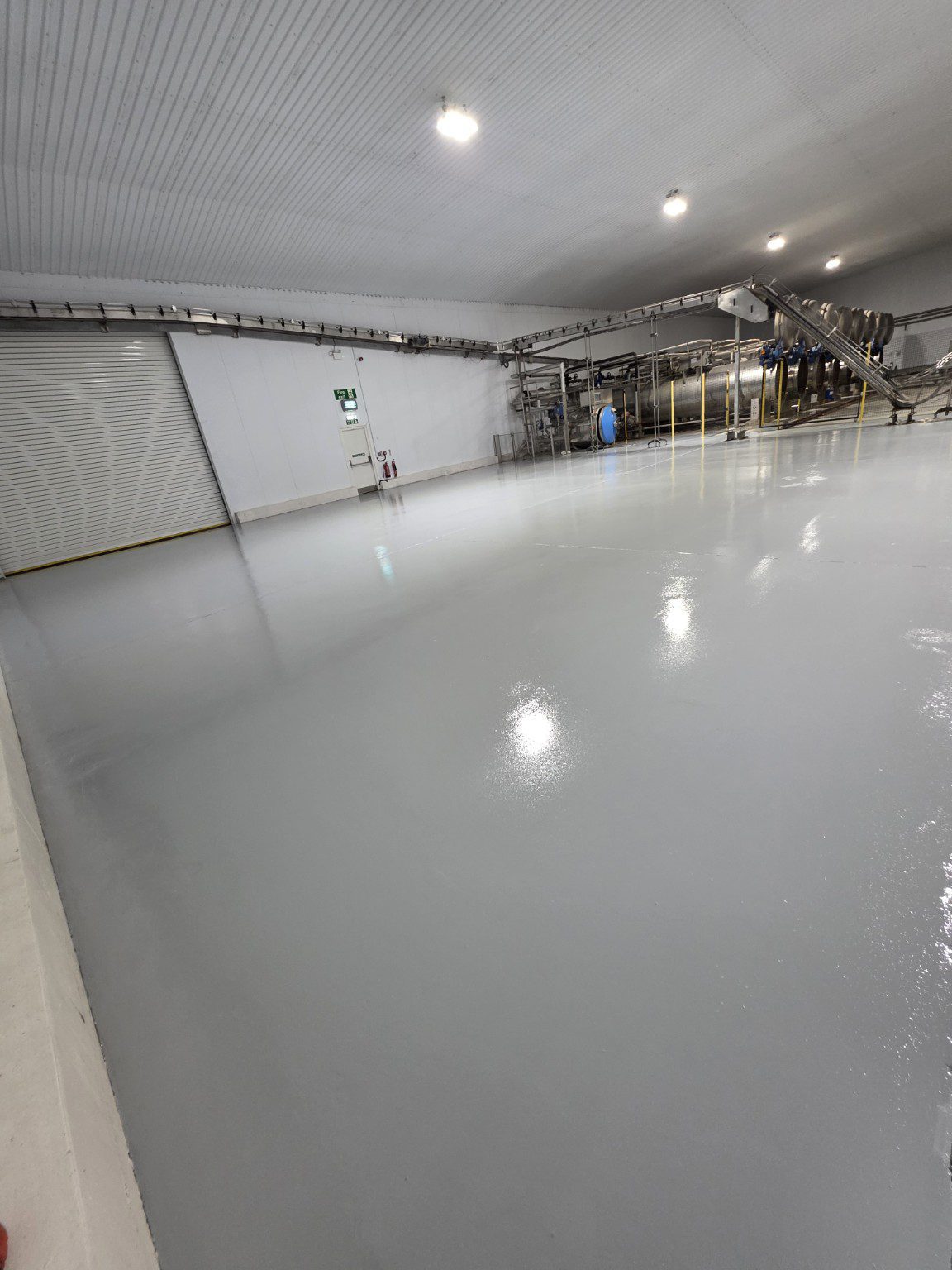 Large light grey manufacturing warehouse floor in Wales featured in SRS resin flooring reviews