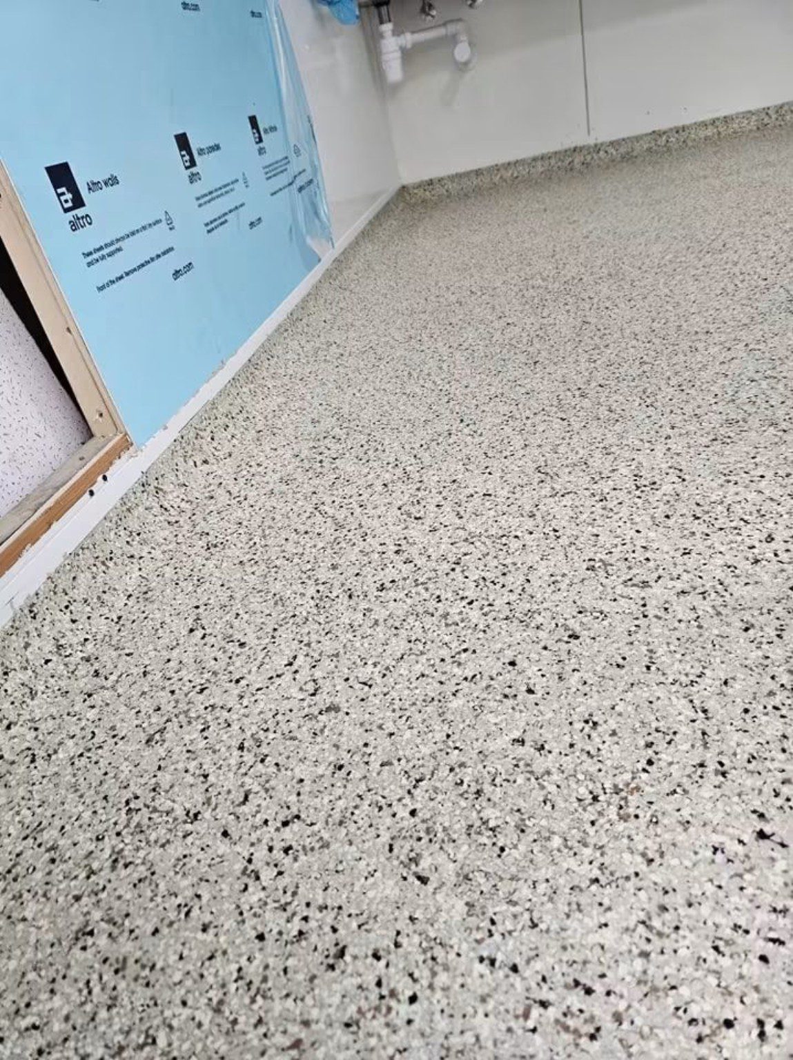 Finished speckled MMA resin flooring beside Altro wall protection in a Cardiff commercial interior.