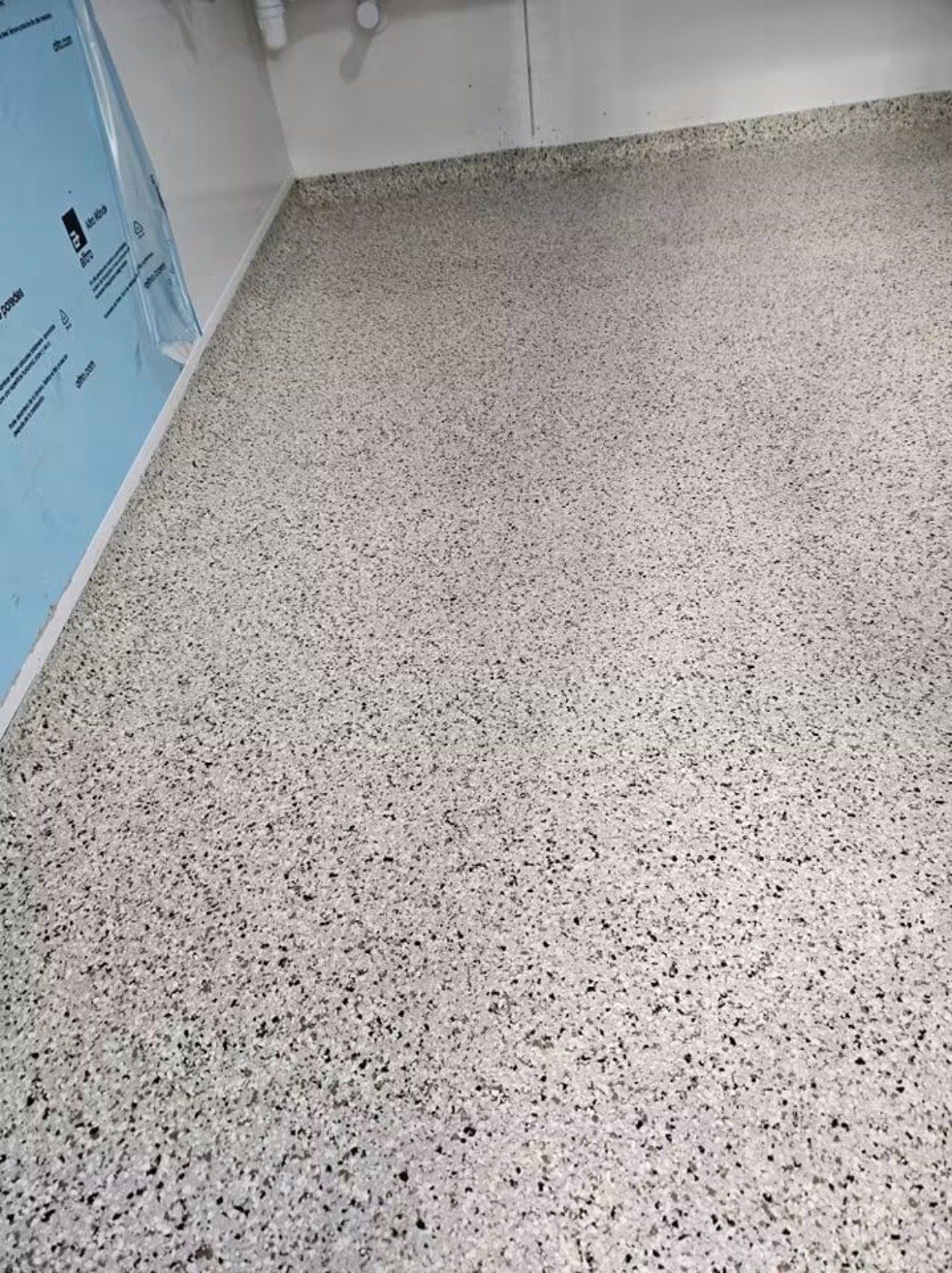 Close view of a light grey speckled MMA resin floor with a coved edge in Cardiff.