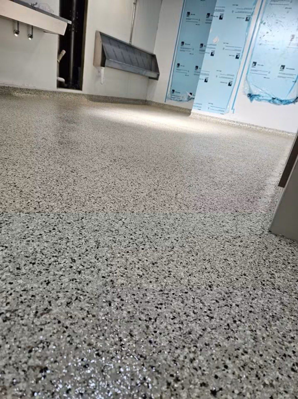 Seamless grey speckled MMA resin flooring and matching wall cove in a Cardiff commercial room.