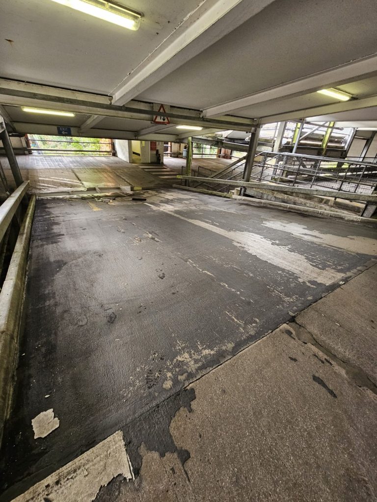 Worn internal car park surfacing before refurbishment in South Wales